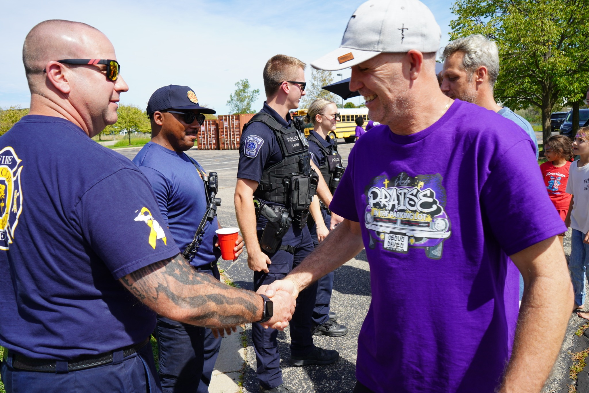 A church volunteer greeting a firefighter at a community event.